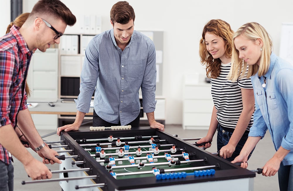 team playing table soccer in the office